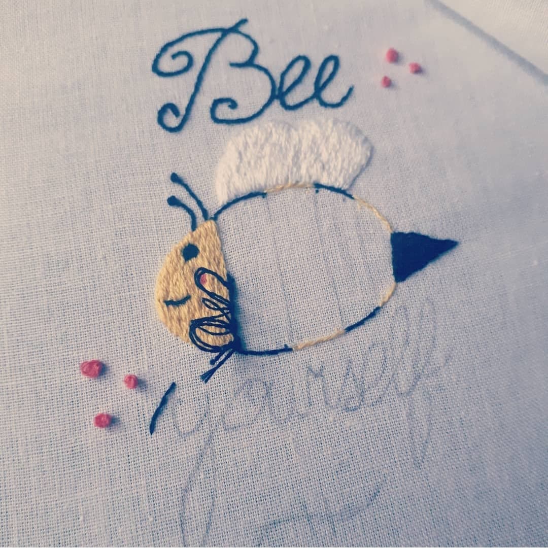 Image of an incomplete embroidery of a bumble bee with the words "Bee Yourself"