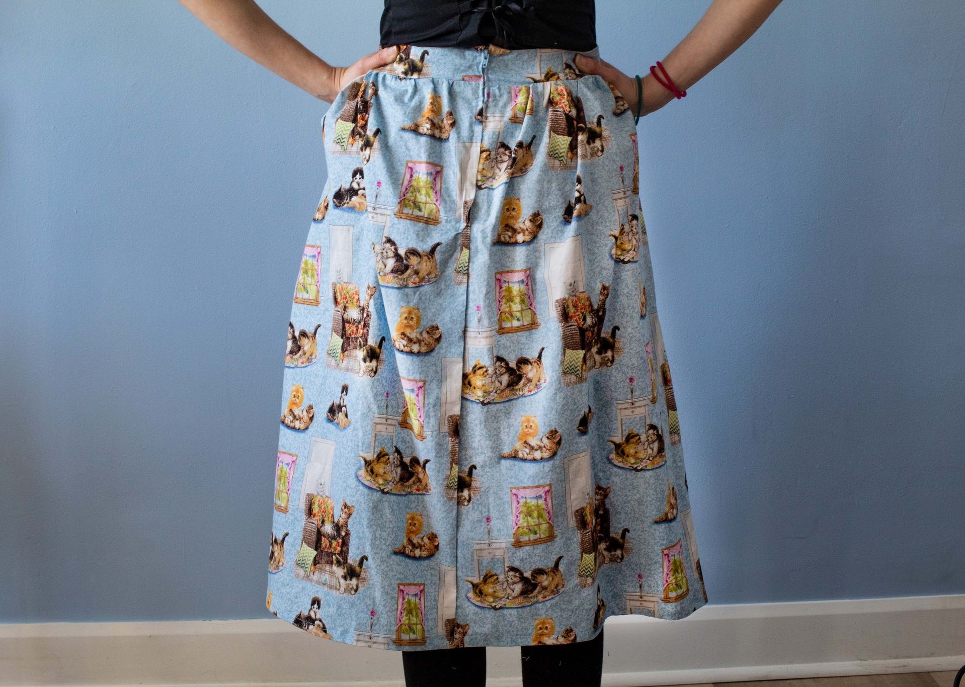 Zoomed in product image of Pixiebob skirt pattern, featuring four kittens playing on and around a  chair